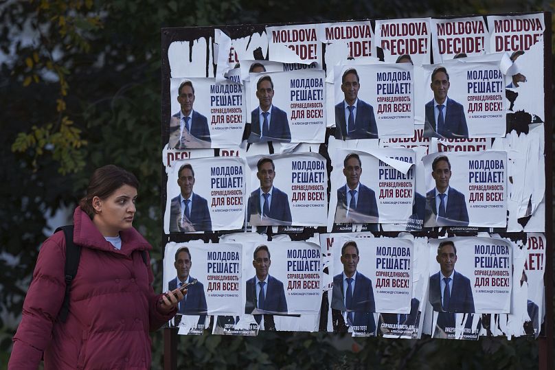 Une femme passe devant des affiches montrant Alexandr Stoianoglo, candidat à la présidentielle du Parti socialiste de Moldavie, le 1er novembre 2024.