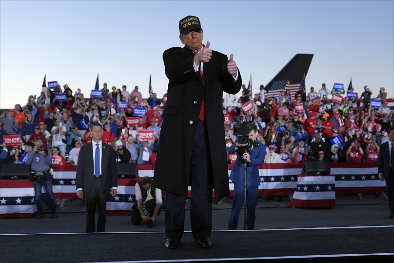 L'ancien président Donald Trump fait des gestes lors d'un rassemblement électoral à l'aéroport régional de Kinston, le 3 novembre 2024.