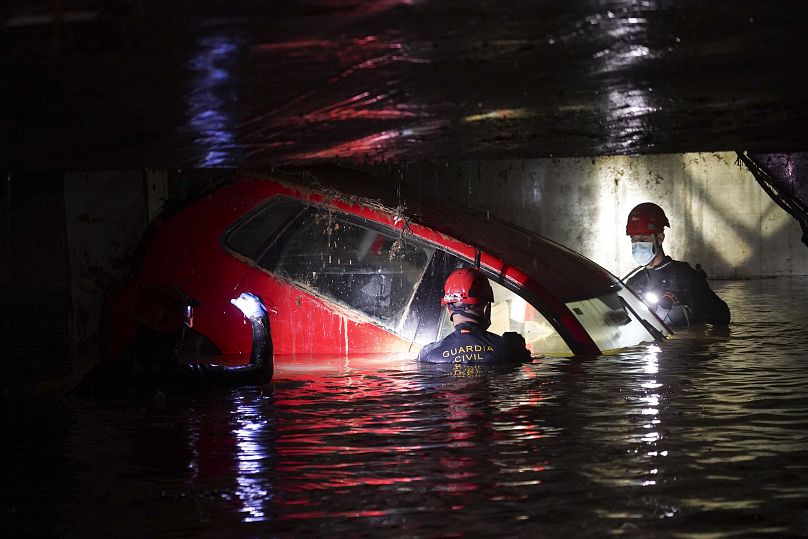 Des gardes civils marchent dans un parking couvert inondé pour vérifier la présence de cadavres dans les voitures après les inondations à Paiporta, près de Valence, en Espagne, le lundi 4 novembre 2024.