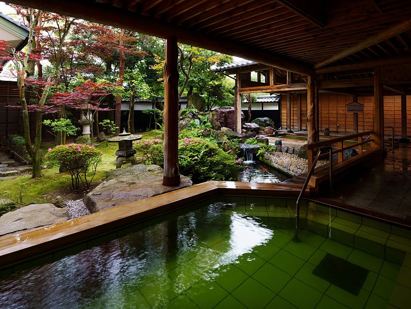 Le bain extérieur nocturne de Tsukioka Onsen Masyuu, avec son eau de source naturelle vert émeraude