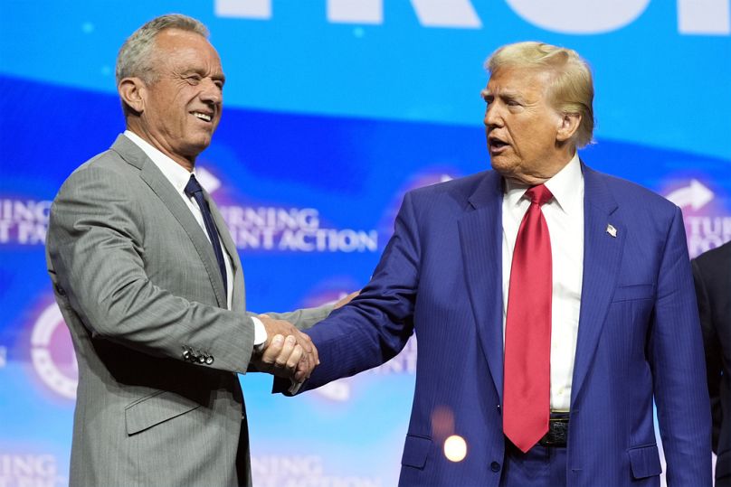 L'ancien président Donald Trump, candidat républicain à la présidentielle, serre la main de Robert F. Kennedy Jr., lors d'un rassemblement électoral Turning Point Action, le mercredi 23 octobre 2024.