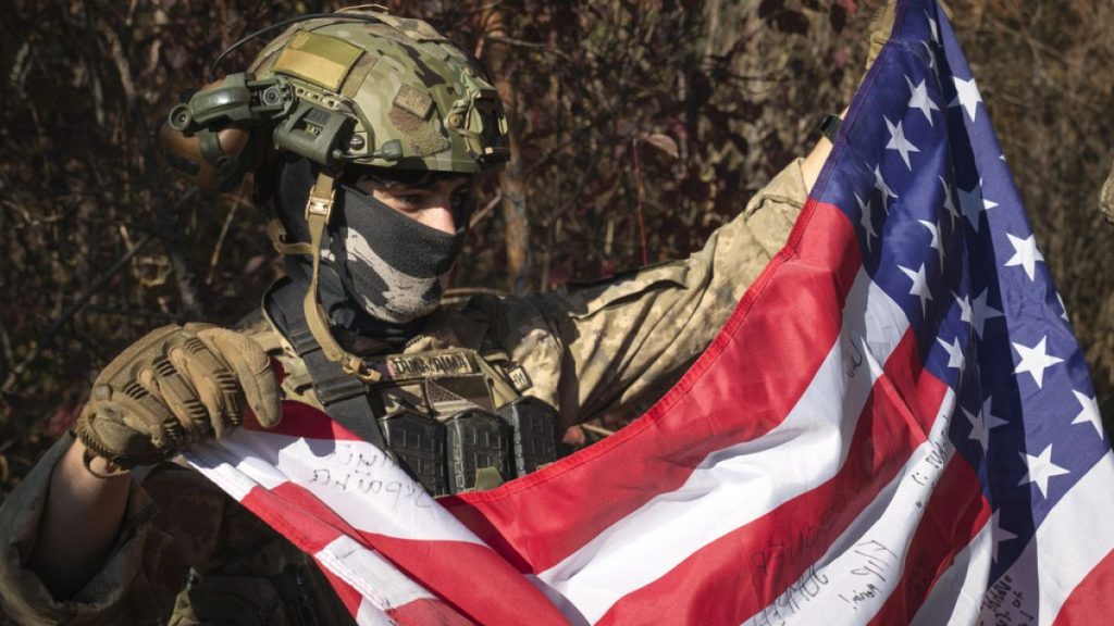 A volunteer fighter from the U.S. state of Texas who serves with the 23rd rifle battalion of Ukraine’s armed forces, holds a U.S. flag  in the Kharkiv region, Oct. 26, 2024.