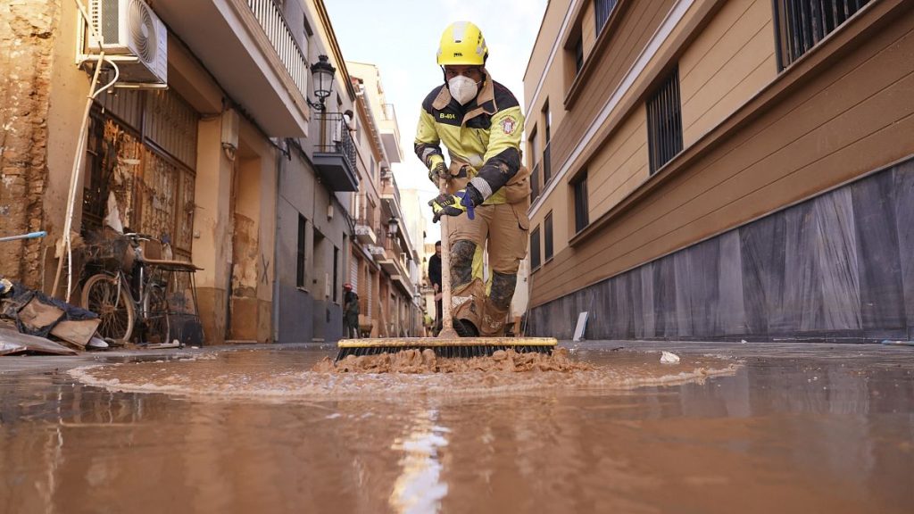 A firefighter sweeps away mud after floods in Paiporta, 7 November, 2024