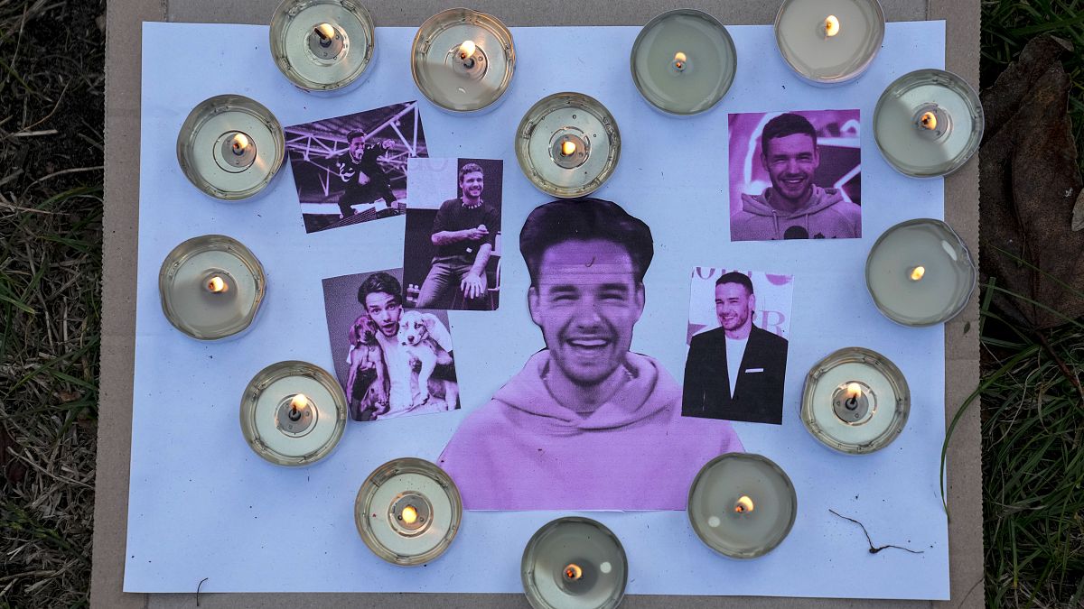 Three people charged in connection with the death of Liam Payne - Pictured here: Pictures and candles are placed as fans gather to pay tribute to Payne