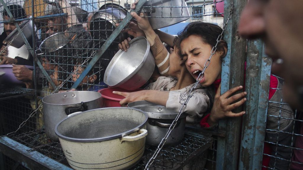 Palestinians line up to receive meals in the Jabaliya refugee camp, 18 March, 2024