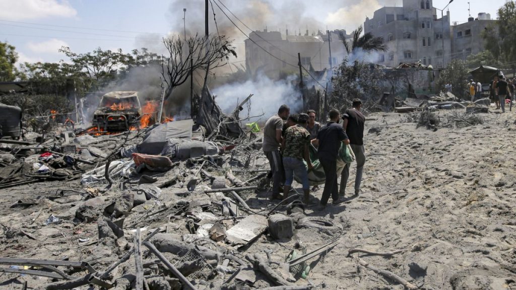 FILE - Palestinians evacuate a body from a site hit by an Israeli bombardment on Khan Younis, southern Gaza Strip, Saturday, July 13, 2024. (AP Photo/Jehad Alshrafi)