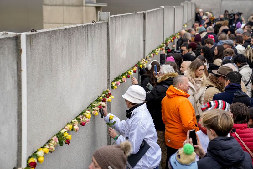 Des gens assistent à une cérémonie de dépôt de fleurs à l'occasion du 35e anniversaire du mur sur le terrain du Mémorial du mur de Berlin, à Berlin, en Allemagne, le samedi 9 novembre 2024. (Photo AP)