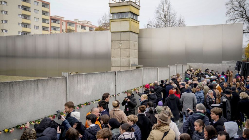 People attend a flower laying ceremony on occasion of the 35th wall anniversary at the grounds of the Berlin Wall Memorial, Berlin, Germany, Saturday, Nov.9, 2024. (AP Photo)