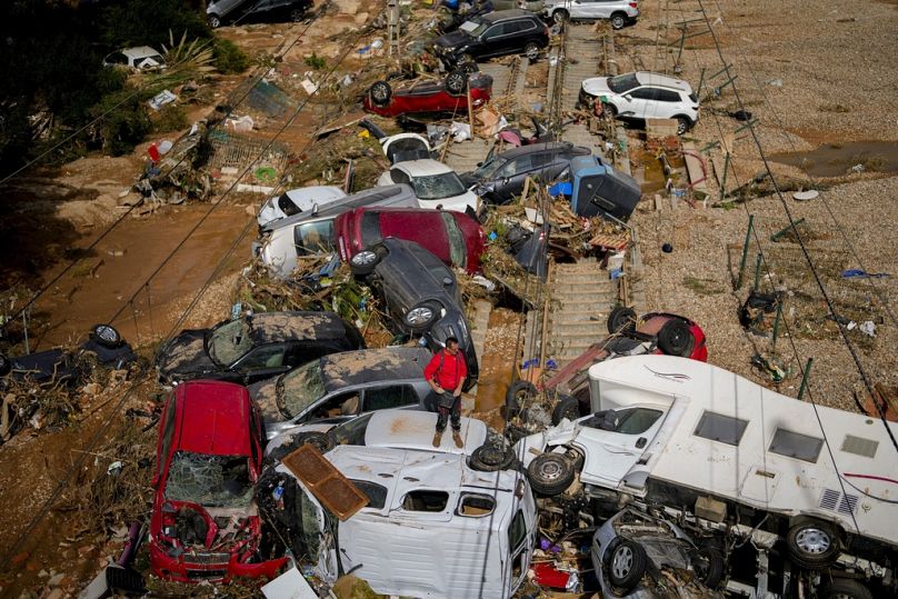 Un homme se tient parmi des voitures inondées entassées à Valence, en Espagne, le jeudi 31 octobre 2024. (AP Photo/Manu Fernandez)