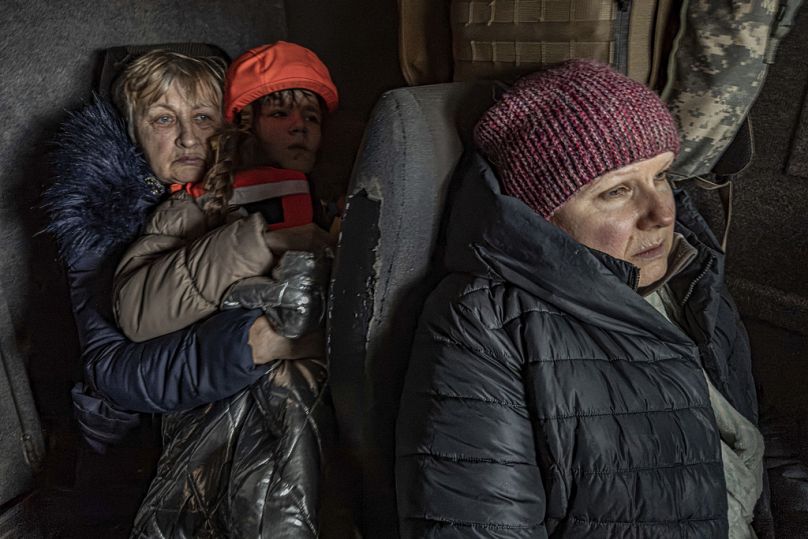 Katia, 11 ans, avec sa grand-mère et sa mère, sont assises dans une fourgonnette blindée pendant l'évacuation par les autorités. 