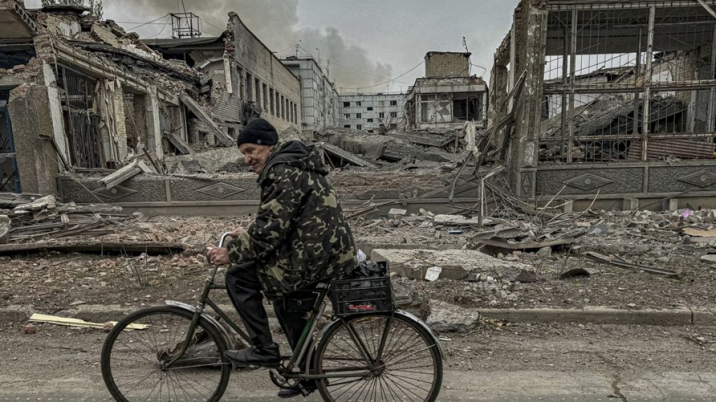 A man rides on a bike in front of the mail office which was destroyed by a Russian airstrike in Kurakhove, Donetsk region, Ukraine, on Nov. 7, 2024. (AP Photo/Anton Shtuka)