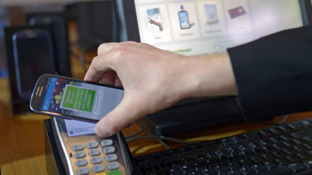 A man uses a mobile device for payment at the Mobile World Congress, the world