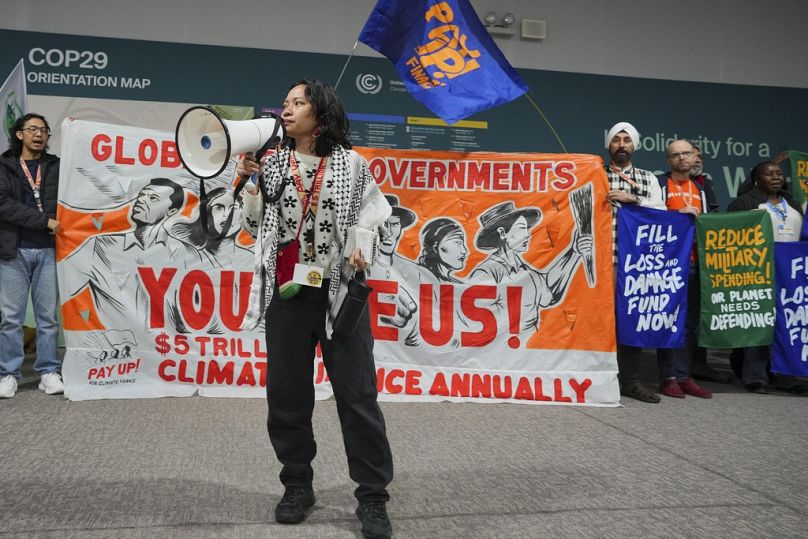 Des militants participent à une manifestation appelant au financement climatique.