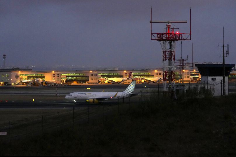 Un avion arrive à l'aéroport de Lisbonne la nuit