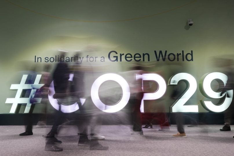 Des gens traversent le Sommet des Nations Unies sur le climat COP29 à Bakou, novembre 2024