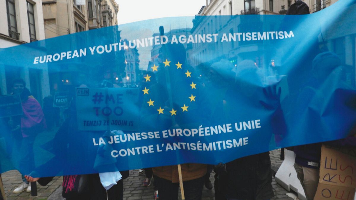 Protesters hold signs and banners as they march during an anti-Semitism demonstration in Brussels, Sunday, Dec. 10, 2023