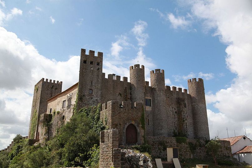 Óbidos abrite un château monumental qui surplombe les maisons blanchies à la chaux de la ville et les rues pavées sinueuses en contrebas. 