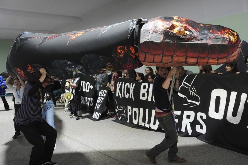 Kevin Buckland, à droite, et d'autres militants participent à une manifestation contre les combustibles fossiles intitulée « Éliminer les serpents » lors de la COP29.