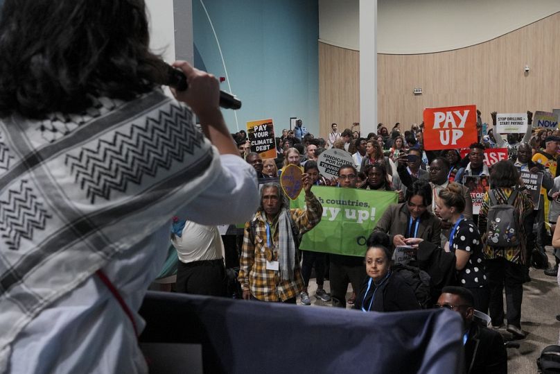 Des militants participent à une manifestation à la COP29. 