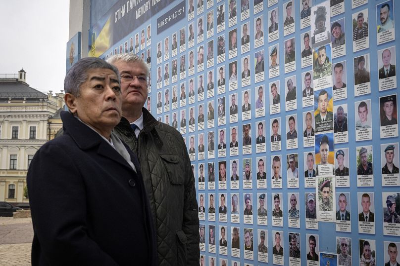 Le ministre japonais des Affaires étrangères Takeshi Iwaya et le ministre ukrainien des Affaires étrangères Andriiy Sybiha regardent les photos des soldats tombés au combat sur le mur commémoratif de Kiev, le 16 novembre 2024.