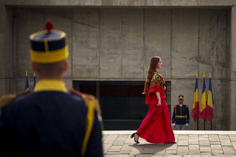 La soprano Isabela Stanescu marche à côté de la garde d'honneur pour interpréter l'hymne rom Djelem, Djelem lors d'une commémoration de la Journée commémorative de l'Holocauste des Roms à Bucarest, en août 2023.