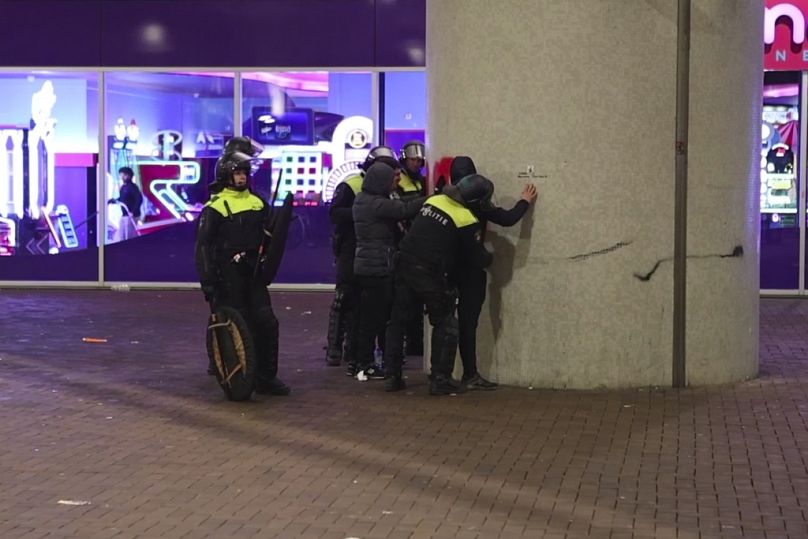 Dans cette image tirée d'une vidéo, la police fouille des supporters pro-palestiniens près du stade de l'Ajax à Amsterdam, aux Pays-Bas, le jeudi 7 novembre 2024.