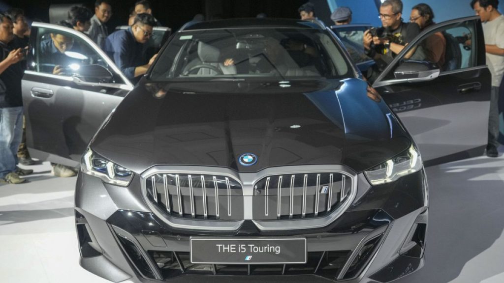 Journalists inspect the interior of a BMW i5 Touring electric car during its launching event in Jakarta, Indonesia Wednesday, Sept. 18, 2024