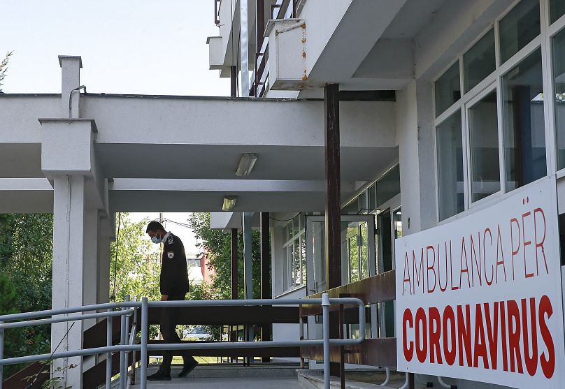 Un agent de sécurité sort du parking des ambulances dédié aux patients atteints du COVID-19 à la Clinique des maladies infectieuses de Pristina, au Kosovo.