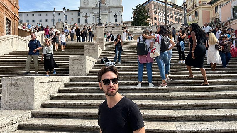 Le journaliste Andrea Carlo devant le monument touristique populaire, la Place d'Espagne, près de chez lui, en septembre 2024. 