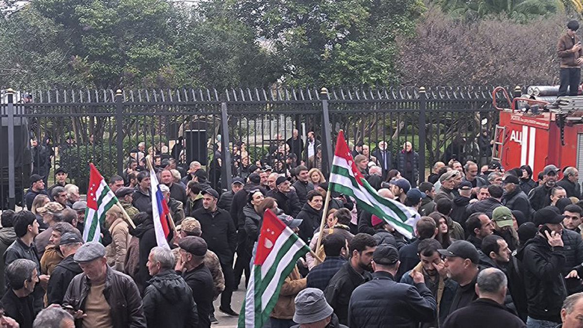 Protesters with Abkhazian flags gather outside the parliament building as tensions flared over a proposed pact that would allowallow Russians to buy apartments in the region