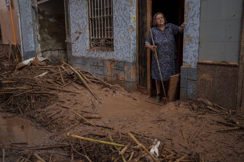 Une femme debout dans sa maison couverte de boue dans une zone touchée par les inondations à Paiporta, le 2 novembre 2024.