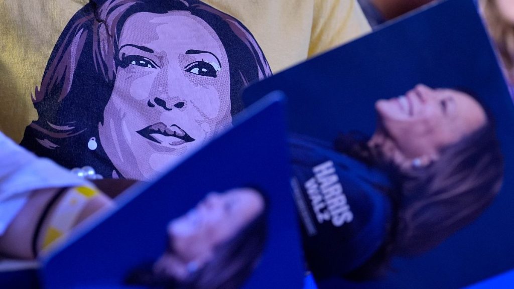 Supporters carry Kamala Harris campaign signs at a rally.