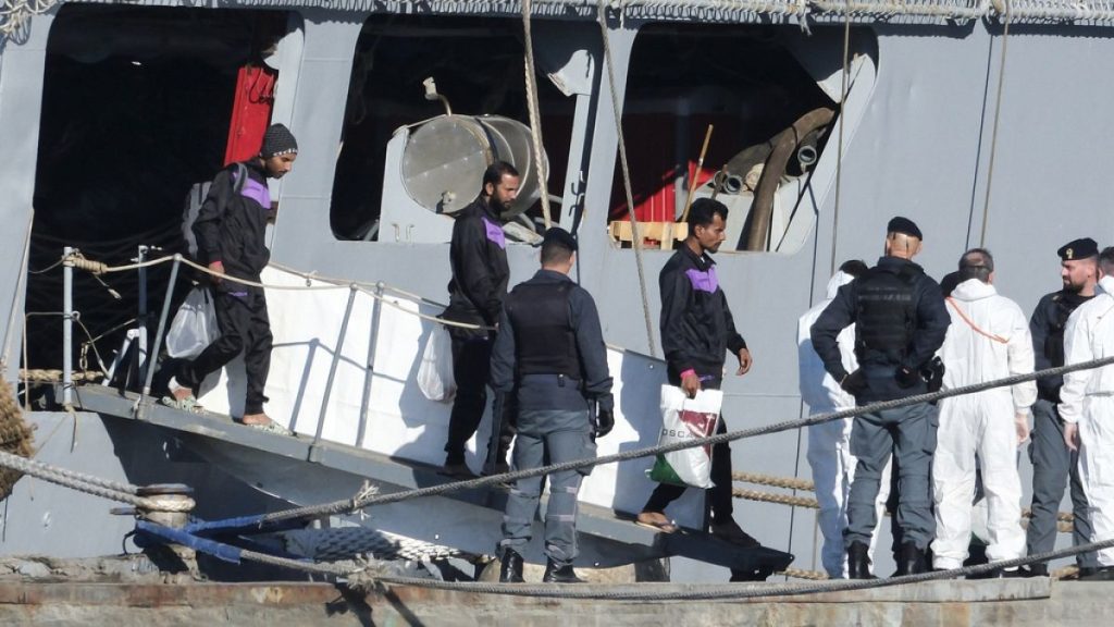 Migrants disembark from the Italian Navy ship Libra in the port of Shengjin, Albania, 8 November 2024