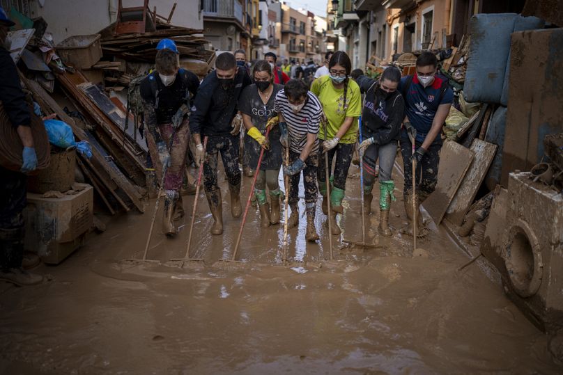 Des bénévoles et des habitants nettoient la boue des rues d'une zone touchée par les inondations à Paiporta, Valence, Espagne, le mardi 5 novembre 2024.