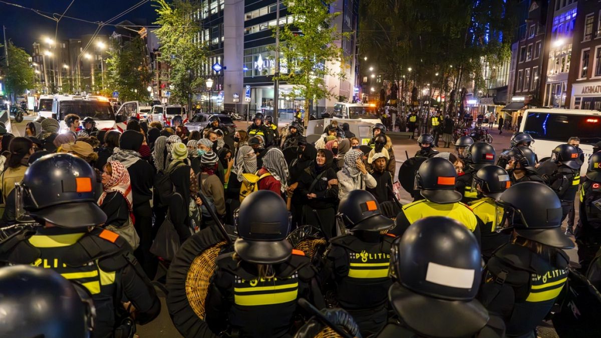 Detained pro-Palestinian demonstrators wait to be bused away following a pro-Israeli commemoration marking the anniversary of the October 7, 2023, Hamas attack, in Amsterdam.