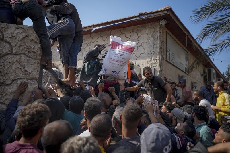 Des Palestiniens se rassemblent pour recevoir des sacs de farine distribués par l'UNRWA à Deir al Balah, le 2 novembre 2024.