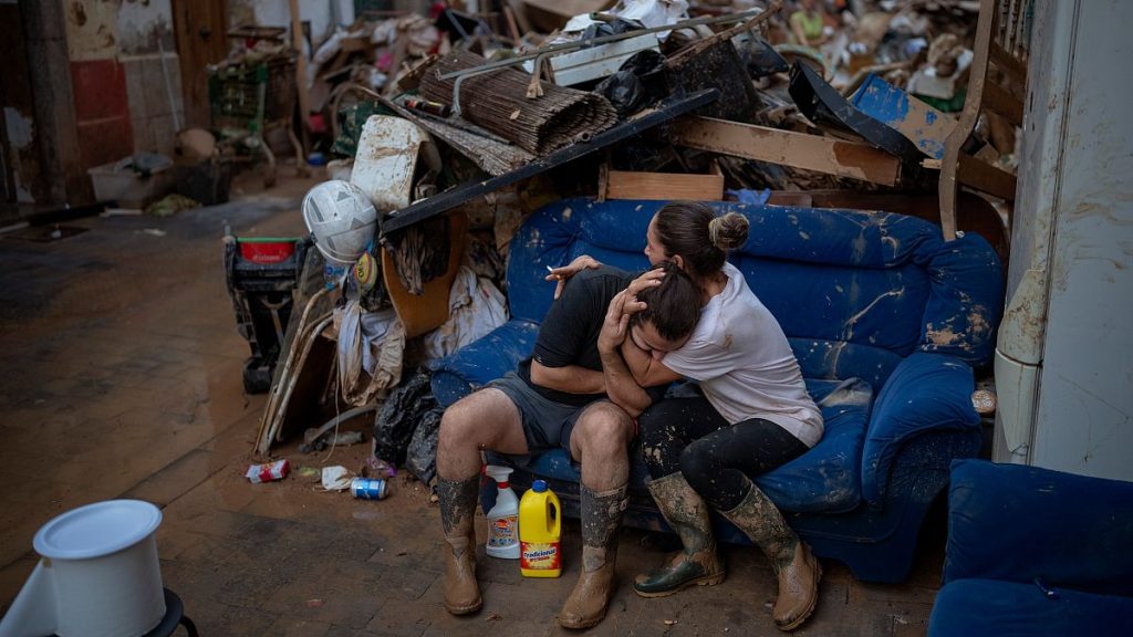 Tania hugs her brother-in-law Baruc after rescuing some of their belongings from their flooded house after the floods in Paiporta, Valencia, Spain, Tuesday, Nov. 5, 2024.