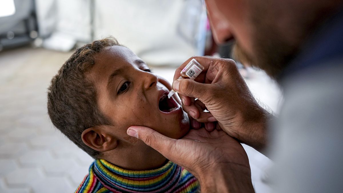 A health worker administers a polio vaccine to a child at a hospital in central Gaza in September 2024.