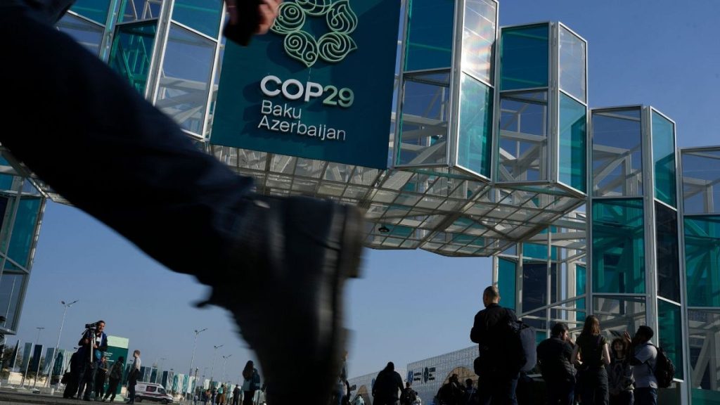 People walk outside the venue for the COP29 UN climate summit, 10 November 2024, in Baku, Azerbaijan.