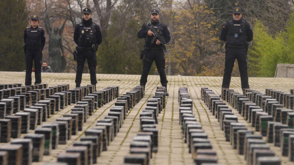 File photo: Police officers stand by part of a haul of cocaine, displayed in the patio of a police station in Madrid, Spain, Tuesday, Dec. 12, 2023.