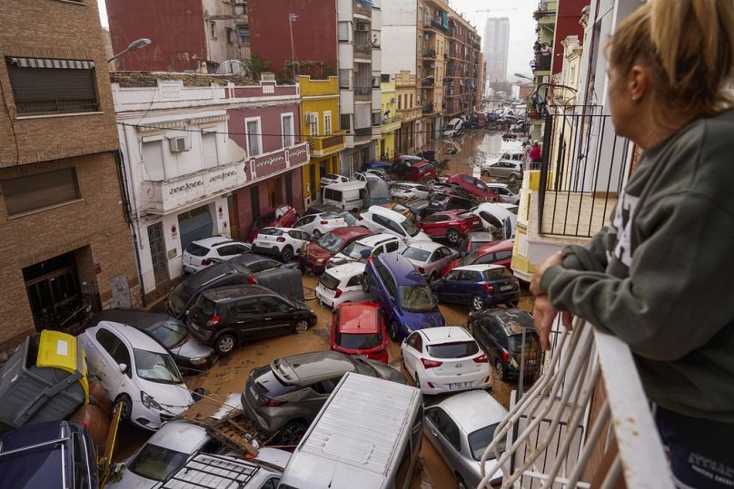 Une femme regarde depuis son balcon alors que des véhicules sont coincés dans la rue lors des inondations à Valence, le mercredi 30 octobre 2024. (AP Photo/Alberto Saiz)