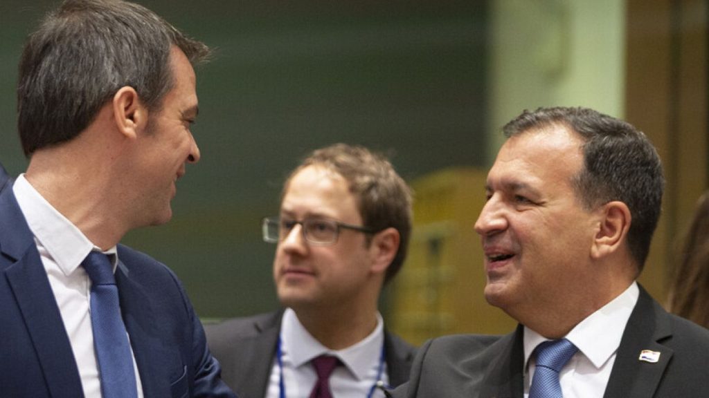 Croatian Health Minister Vili Beros, right, bumps elbows to say hello to French Health Minister Olivier Veran during an EU meeting in Brussels, March 6, 2020.