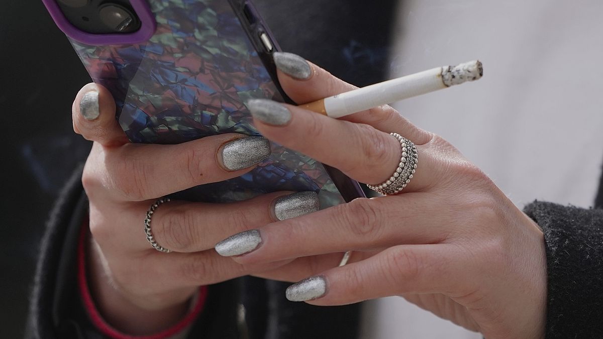 A woman smokes on a street in London, on April 16, 2024.