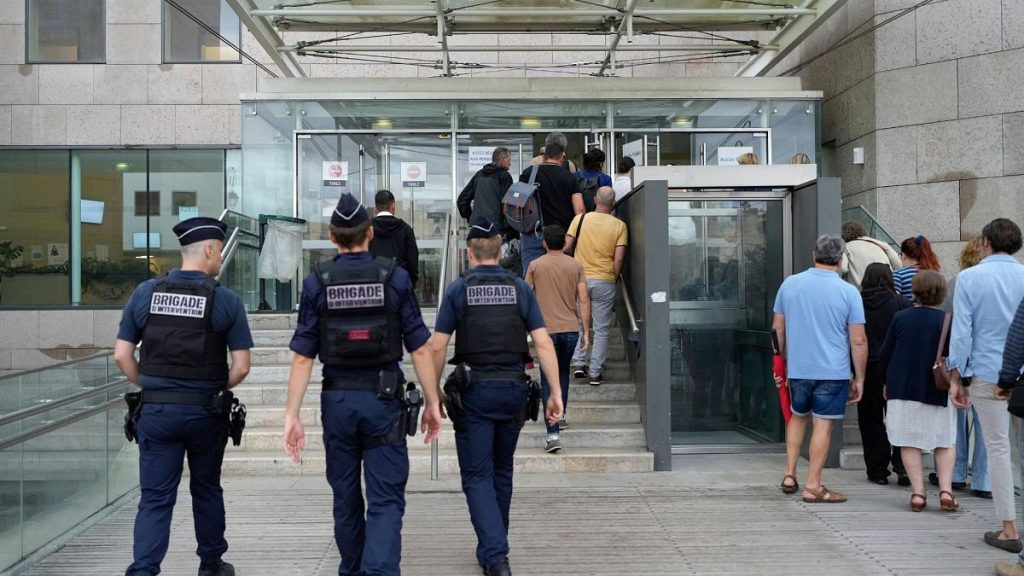 Police officers walk in the Avignon court house prior to the trial of Dominique Pelicot, in Avignon, southern France, 5 September 2024