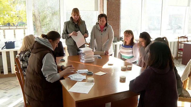 Des agents électoraux préparent les bulletins de vote dans un bureau de vote de la capitale Chișinău, le 2 novembre 2024.