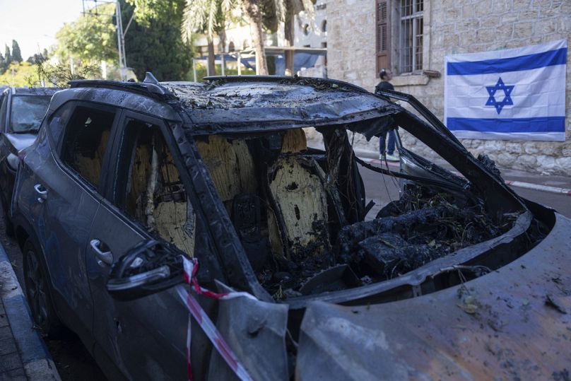 Une voiture détruite qui a été touchée par un missile tiré depuis le Liban samedi, à Haïfa, dans le nord d'Israël, le dimanche 17 novembre 2024. (AP Photo/Ohad Zwigenberg)