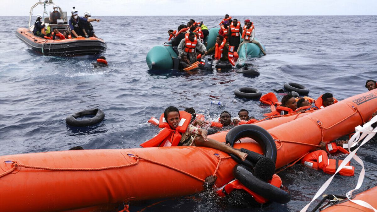 File photo: Migrants aboard a rubber boat end up in the water around 35 miles away from Libya, in Libyan SAR zone, Monday, Oct. 18, 2021.