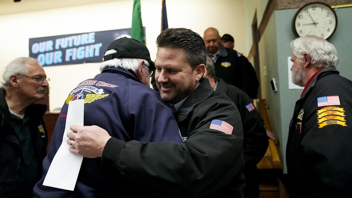 Seattle union leader Jon Holden greets union members after announcing they had voted to accept a new contract offer from Boeing