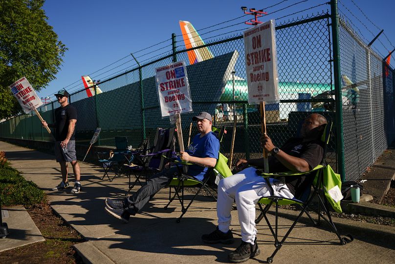 Les machinistes portent des pancartes à l'extérieur des installations de l'entreprise à Renton, Washington