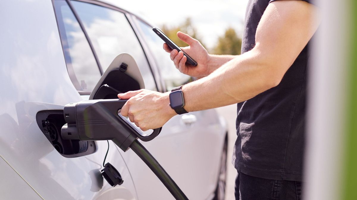 A man charging an electric car